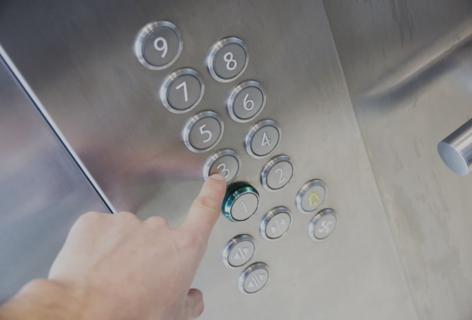 Osoba wybiera numer na panelu windy